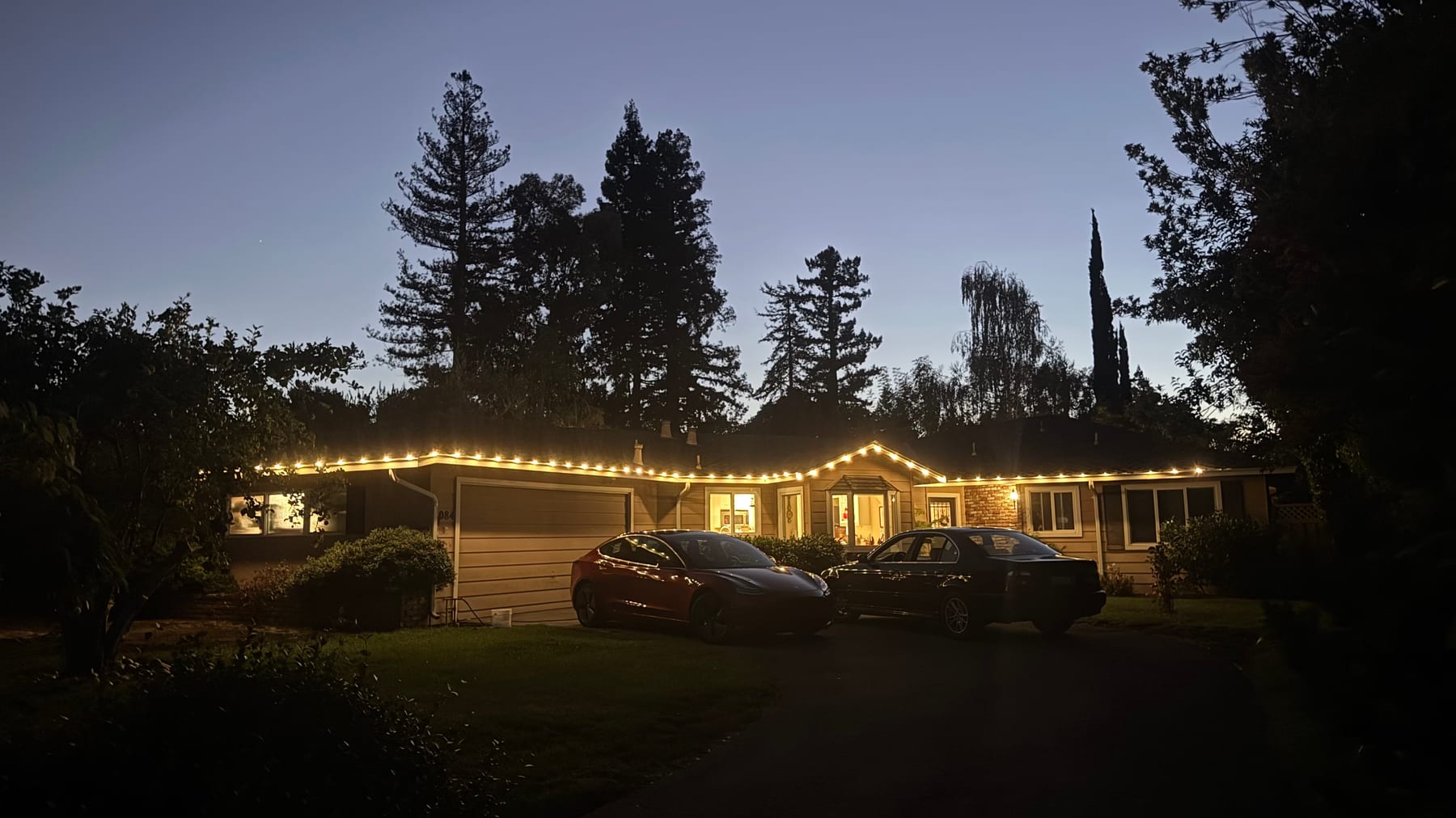 Warm white roofline lights on a home at night